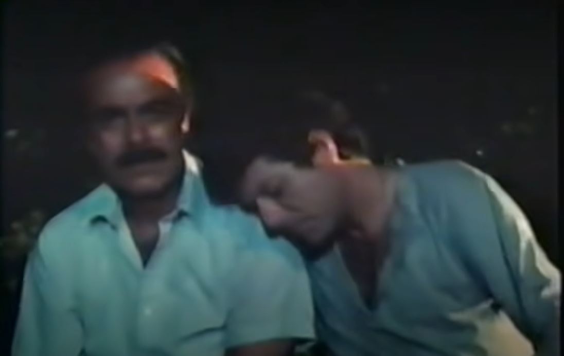 A different, unobscured shot of Julio and his son on the bridge while zooming in