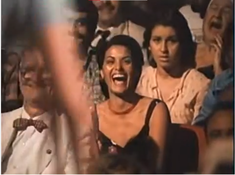 Lina sitting in an audience, laughing