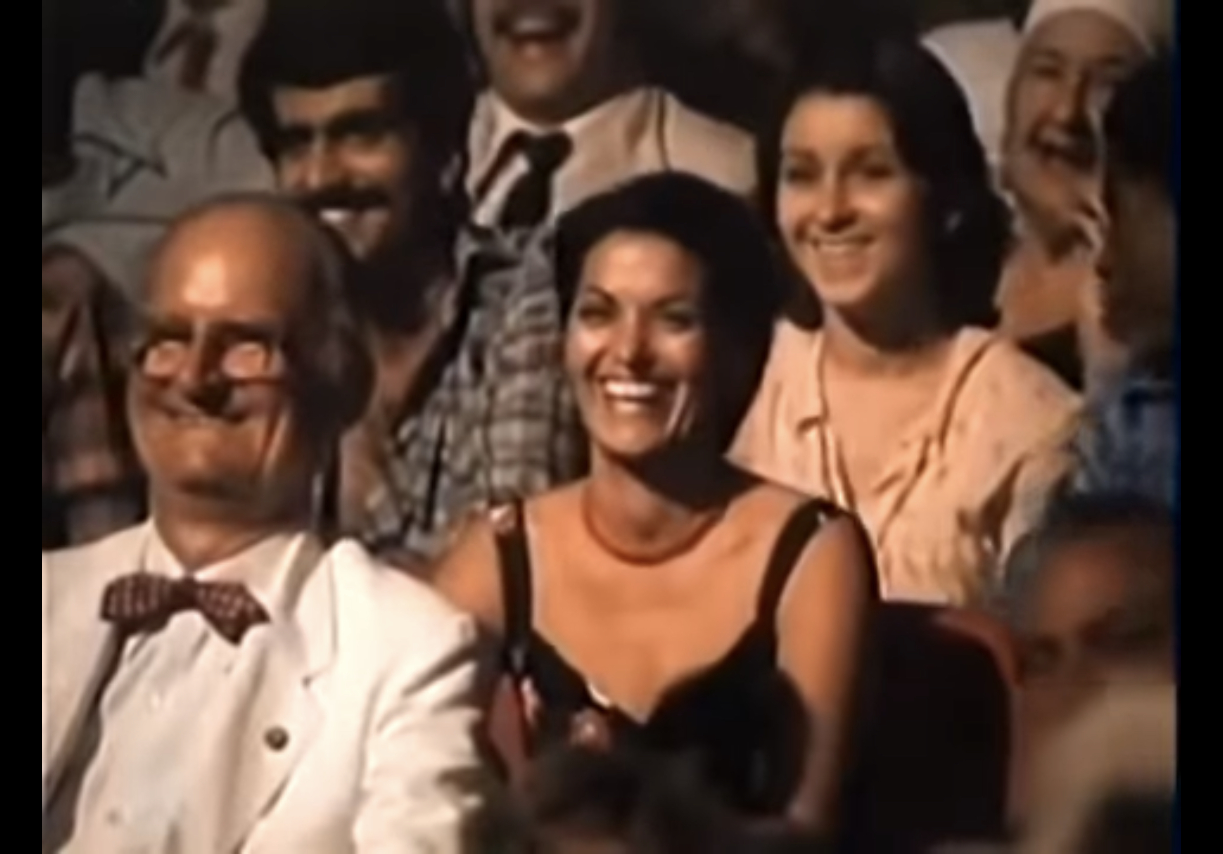 Lina laughing sitting in the audience. 