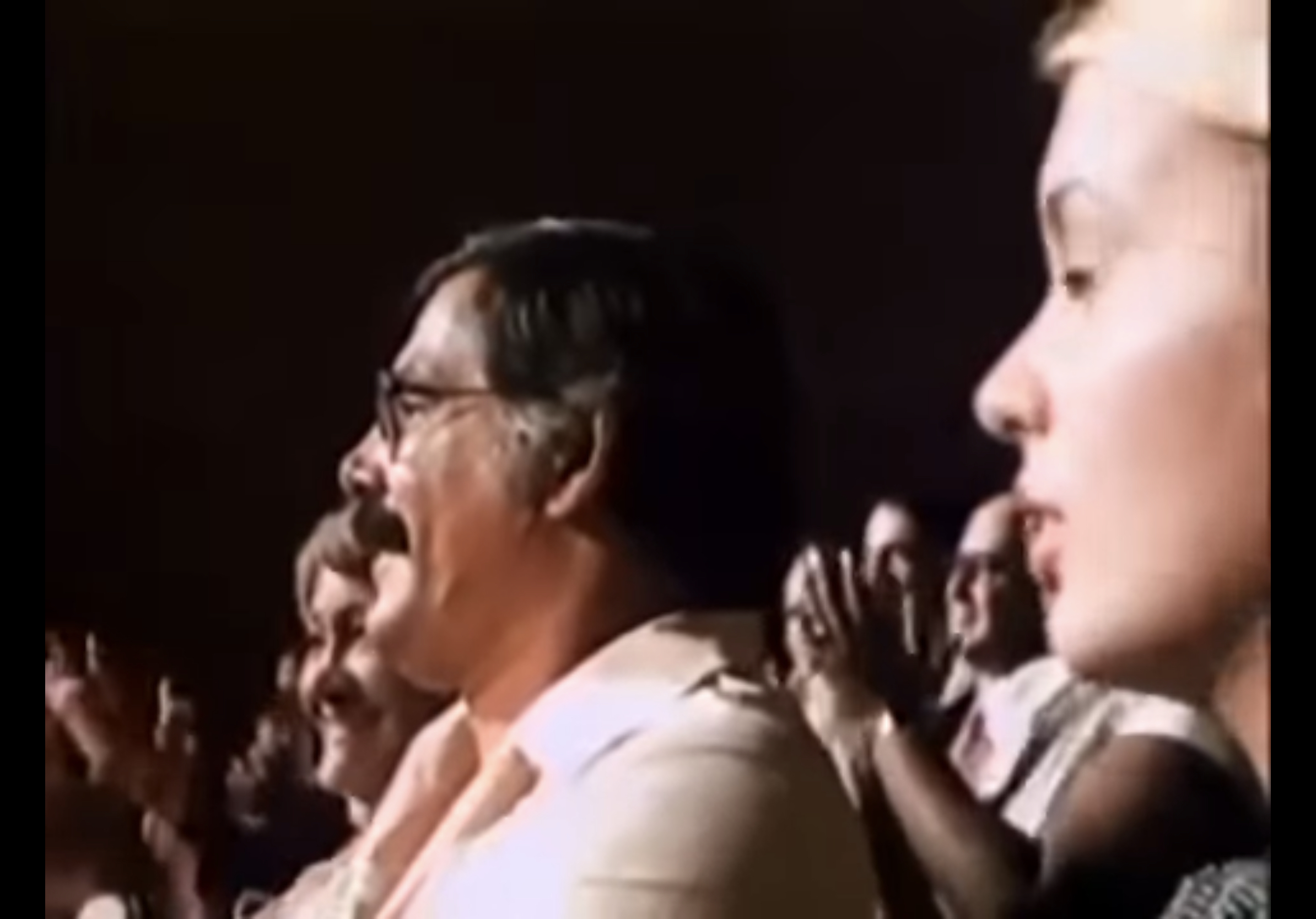 Oscar sitting in the crowd with the audience clapping around him