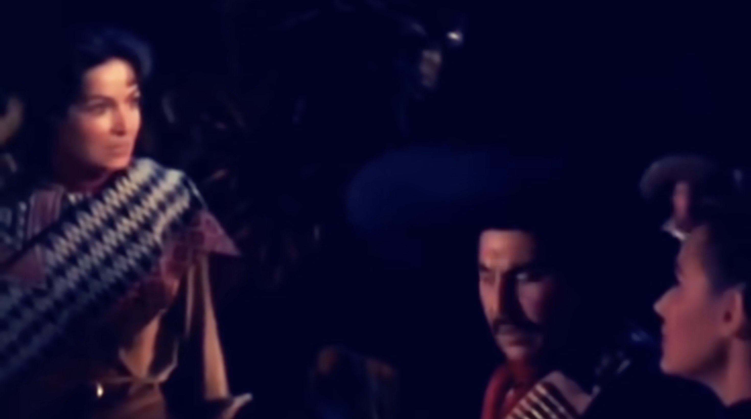 Still from La Cucaracha (1959) showing Cucaracha positioned above Colonel Zeta and Isabel in a nighttime confrontation, her arm raised toward the couple.