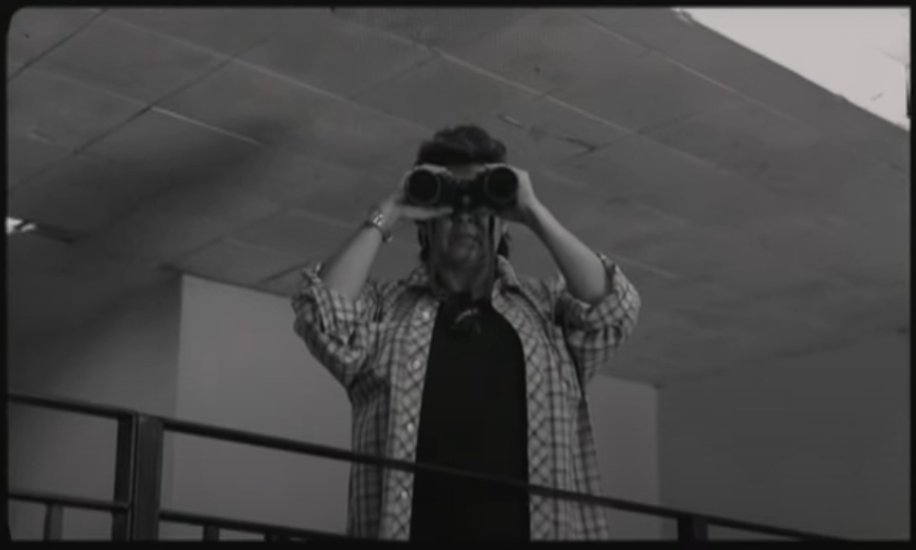 Cervera wearing binoculars on top of a balcony