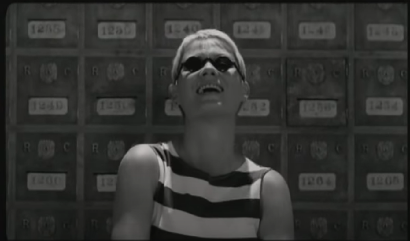 Carla laughing and wearing sunglasses in the mailroom