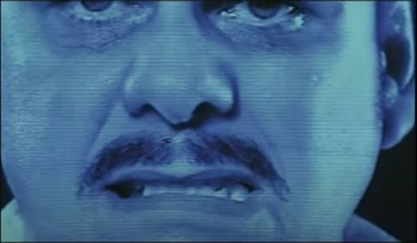 Extreme closeup of Professor Calzado as he cries reading the letter on screen. 