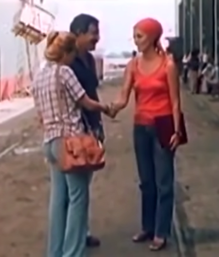 Marián wears a striped white and black shirt while Oscar wears a dark polo. While Lina wears a bright pink, working outfit.