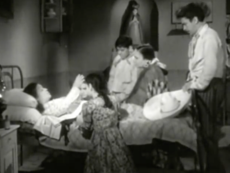 (00:07:21-00:10:25). Most of the scene in this still is in shadow, except for the mother of José Francisco and Eulalia. At this moment she is praying for her family and friends by making the sign of the cross in the air. The light represents the religion and the pureness in her.