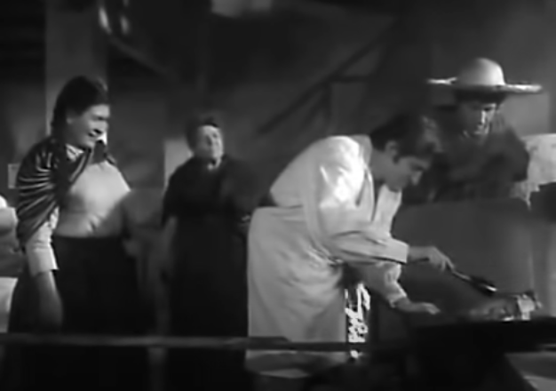 Macario and others watch as the butcher places on of the large turkeys in the oven.