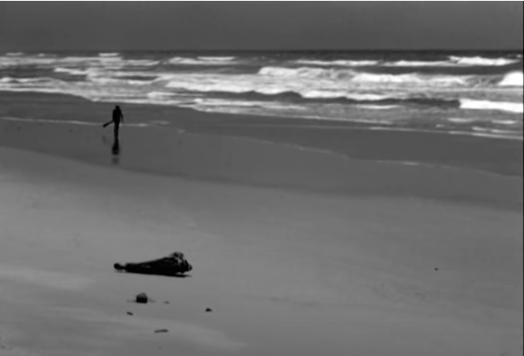 Opening scene of a man walking across a beach.