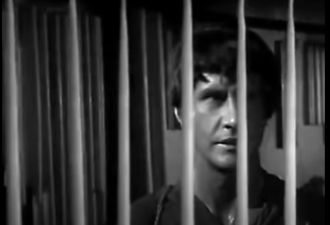 Macario behind a spinning wheel of long candles.