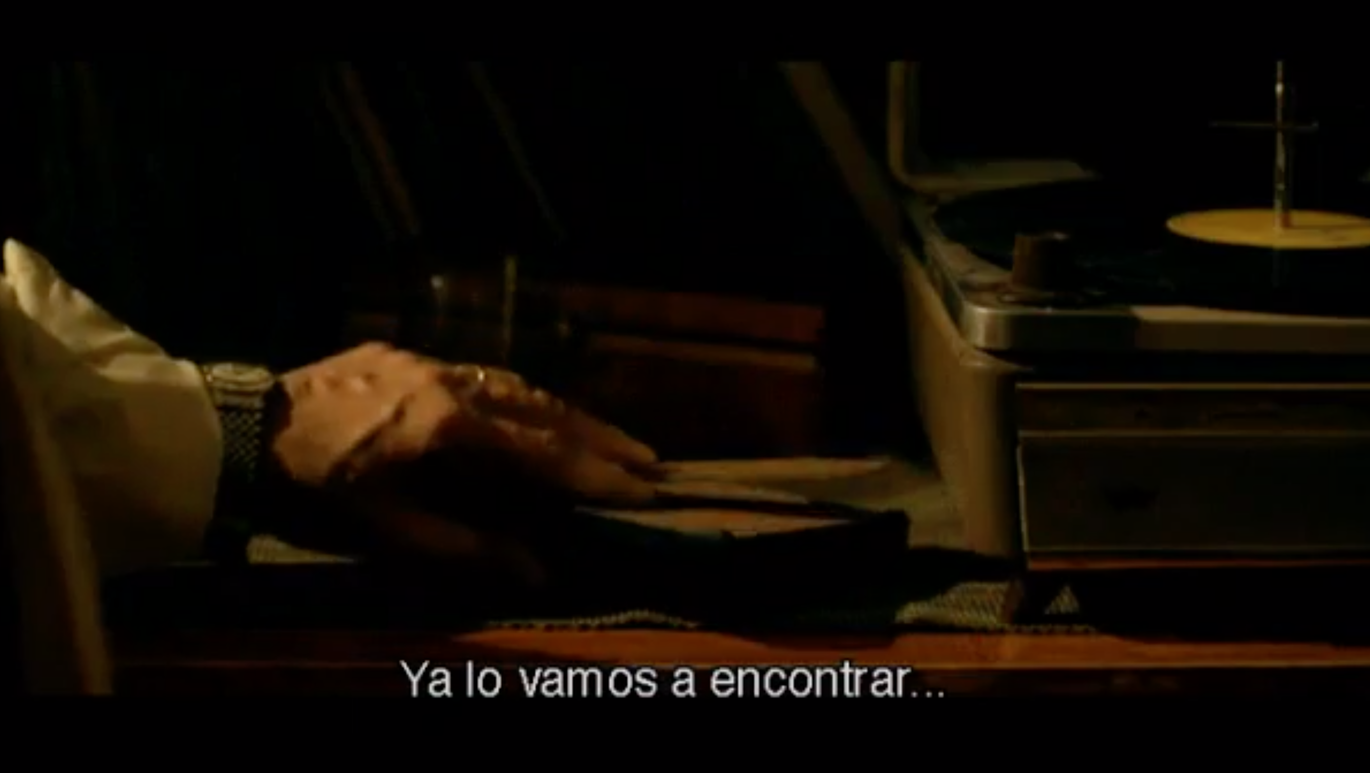 In this image, we see Sandoval turning over a portrait of Espósito at his home in order to protect Espósito from the murderers discovering his true identity. It is an act of sacrifice as Sandoval is mistakenly killed afterward.