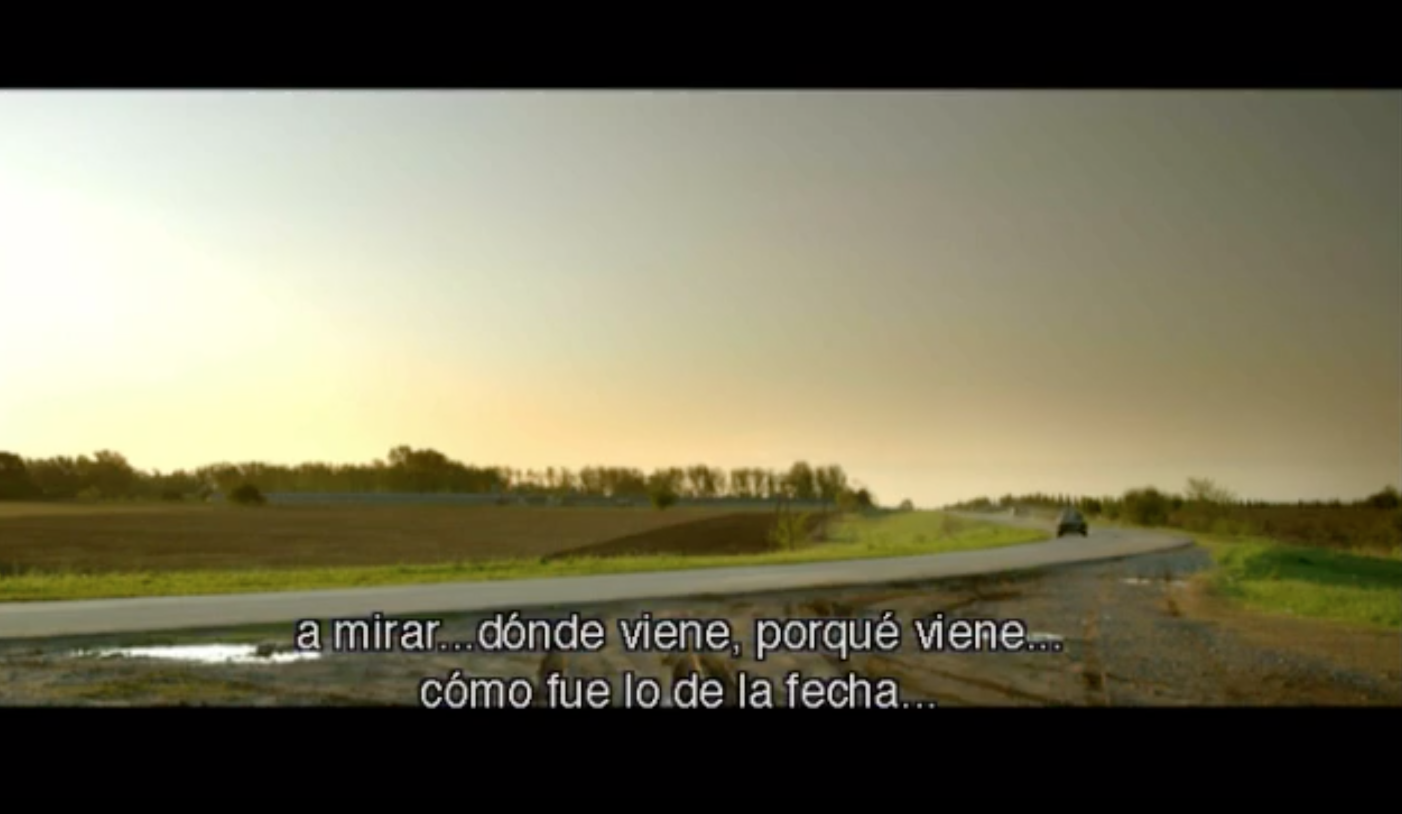 We see the agent's car driving over an empty road in rural Argentina.