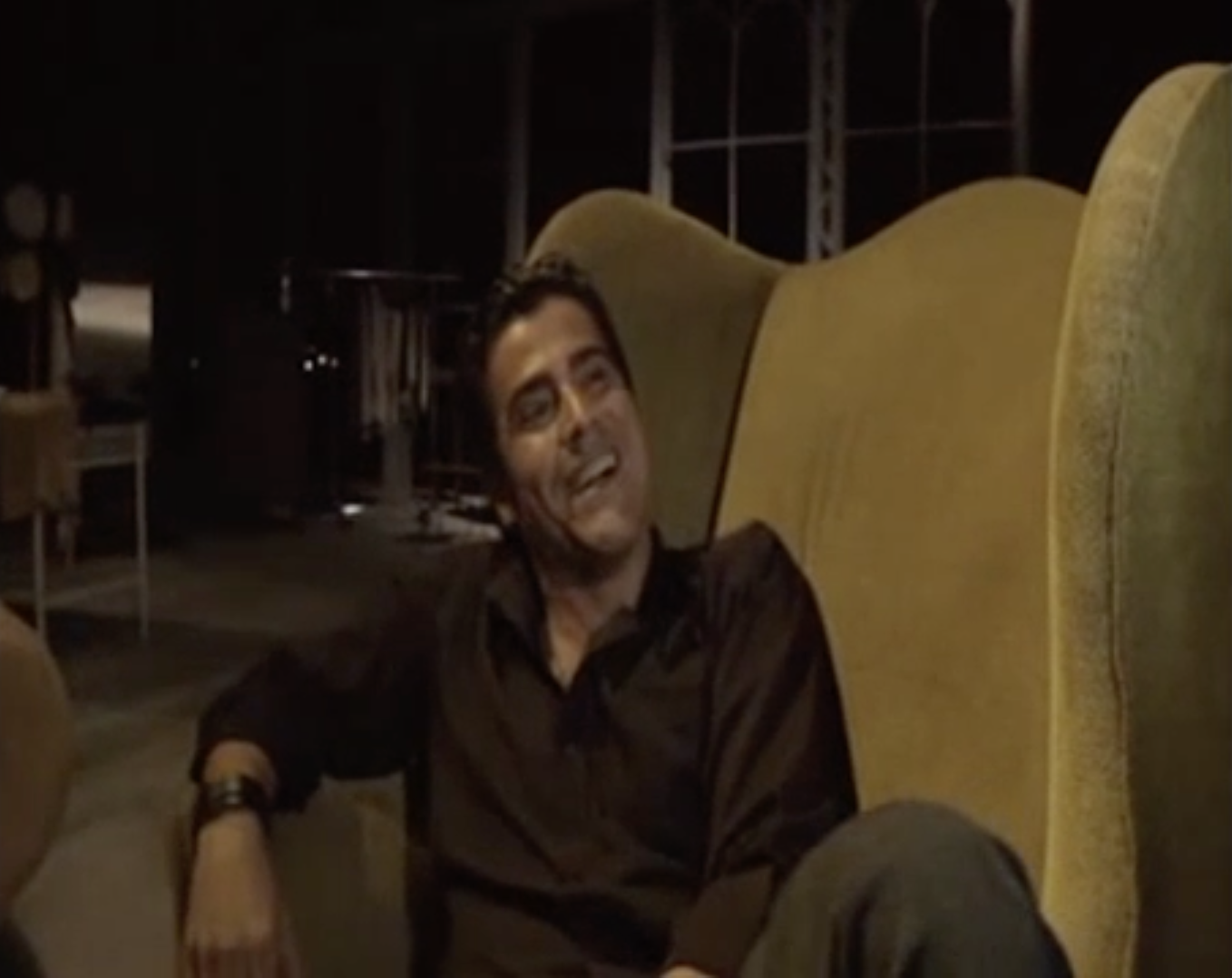 Carlos en el apartamento. El fondo es muy oscuro y vacío.