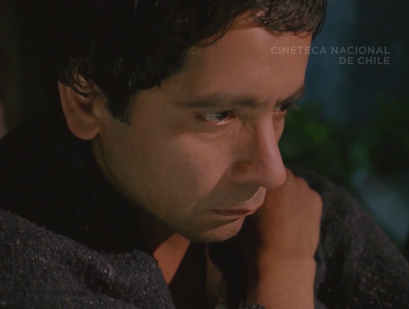 Ramiro's somber expression illuminated by a light at an angle. 