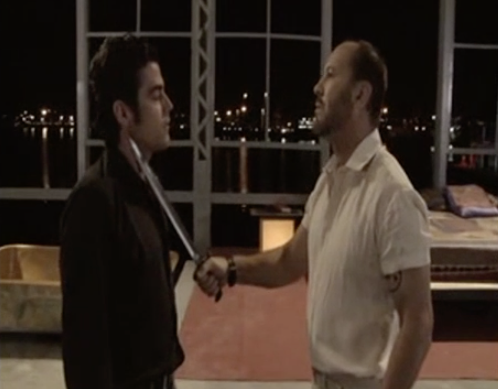 Alfredo punta la espada hacia el cuello de Carlos.