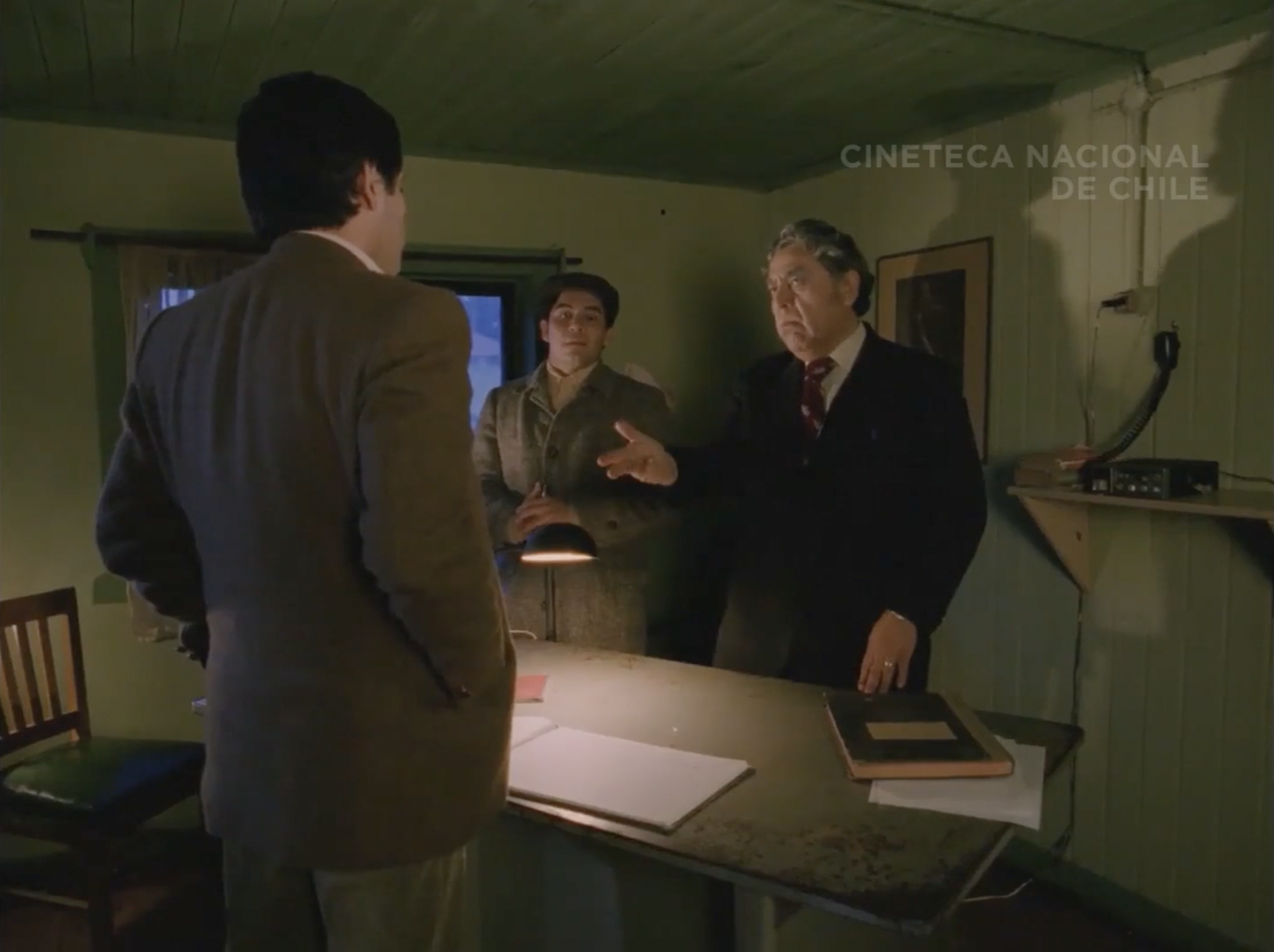 Registration office scene- Ramiro with the two other men who wait for him to sign in