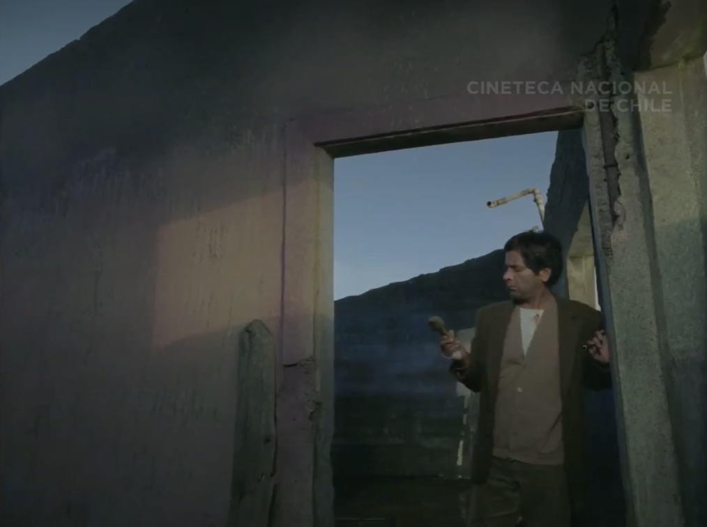 Ramiro at the doorway of ruined house.