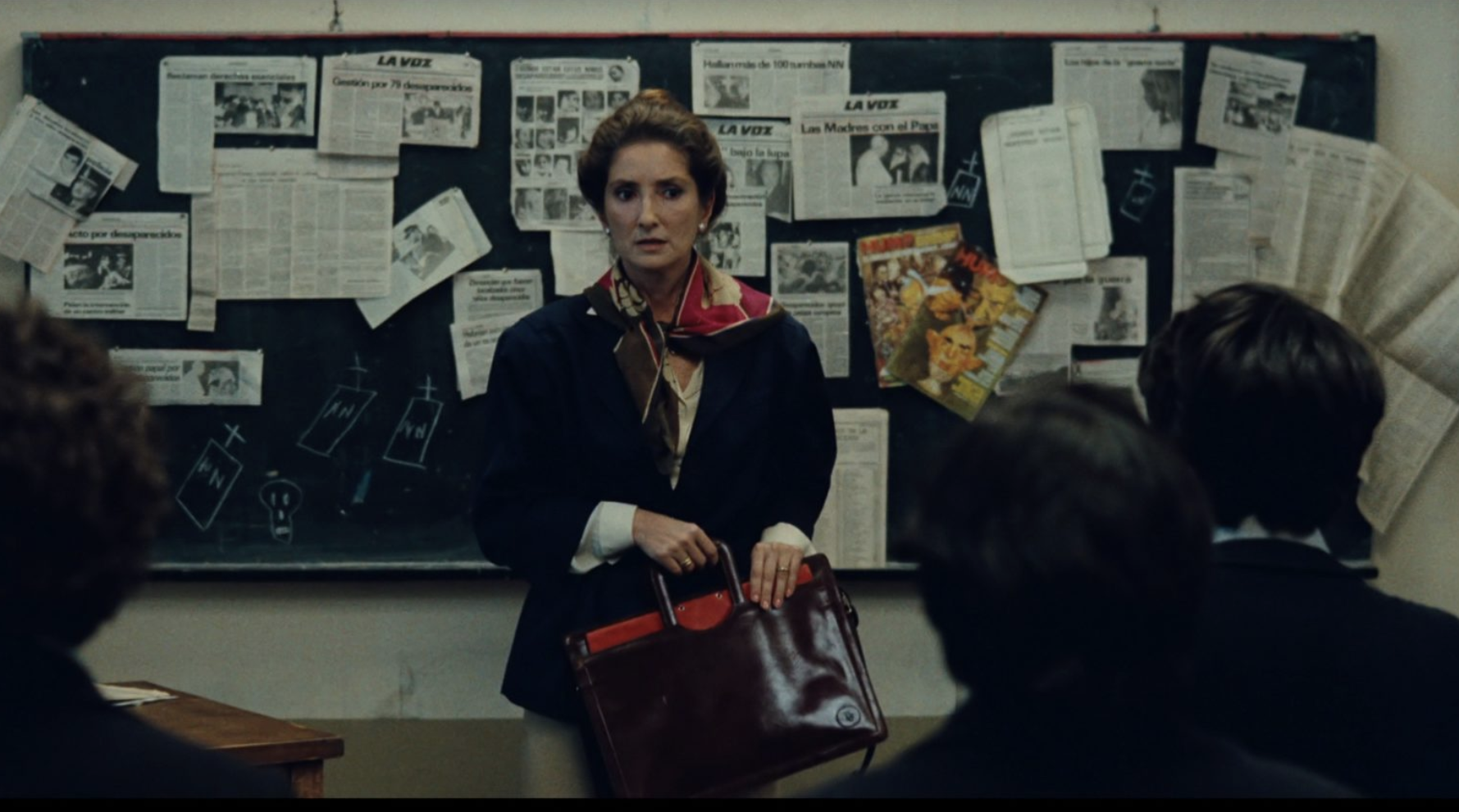 Alicia in the classroom seeing the newspapers of Los Desaparecidos