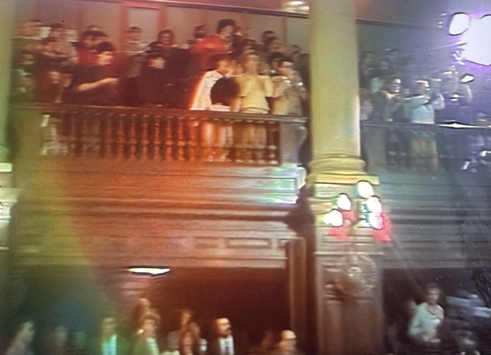 Julio Strassera addressing a case-related phone call with the Argentine flag looming behind him.