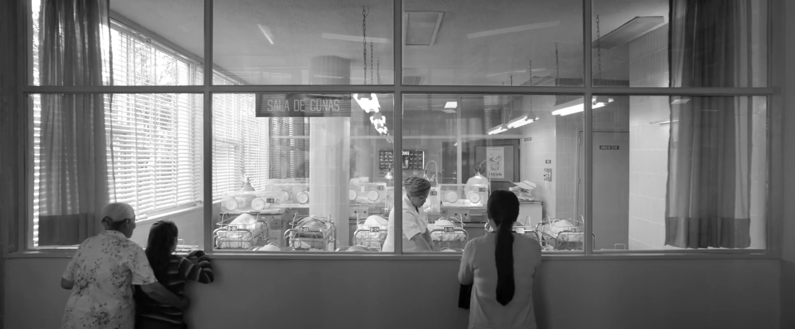 A wide shot of Cleo as she looks at a nursery. She is completely off center in the shot to the point where only her torso is captured.