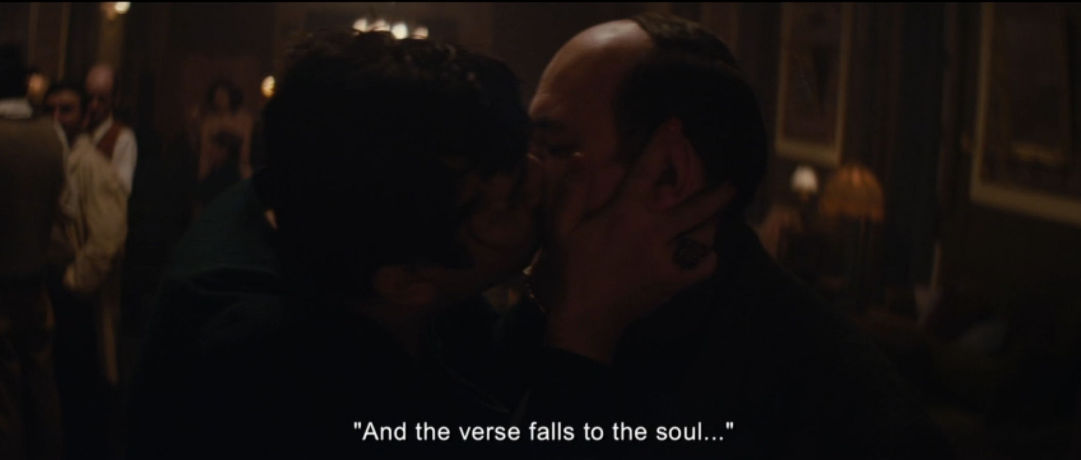 In a dark bar, a male singer kisses Neruda on the mouth after hearing him recite a poem.
