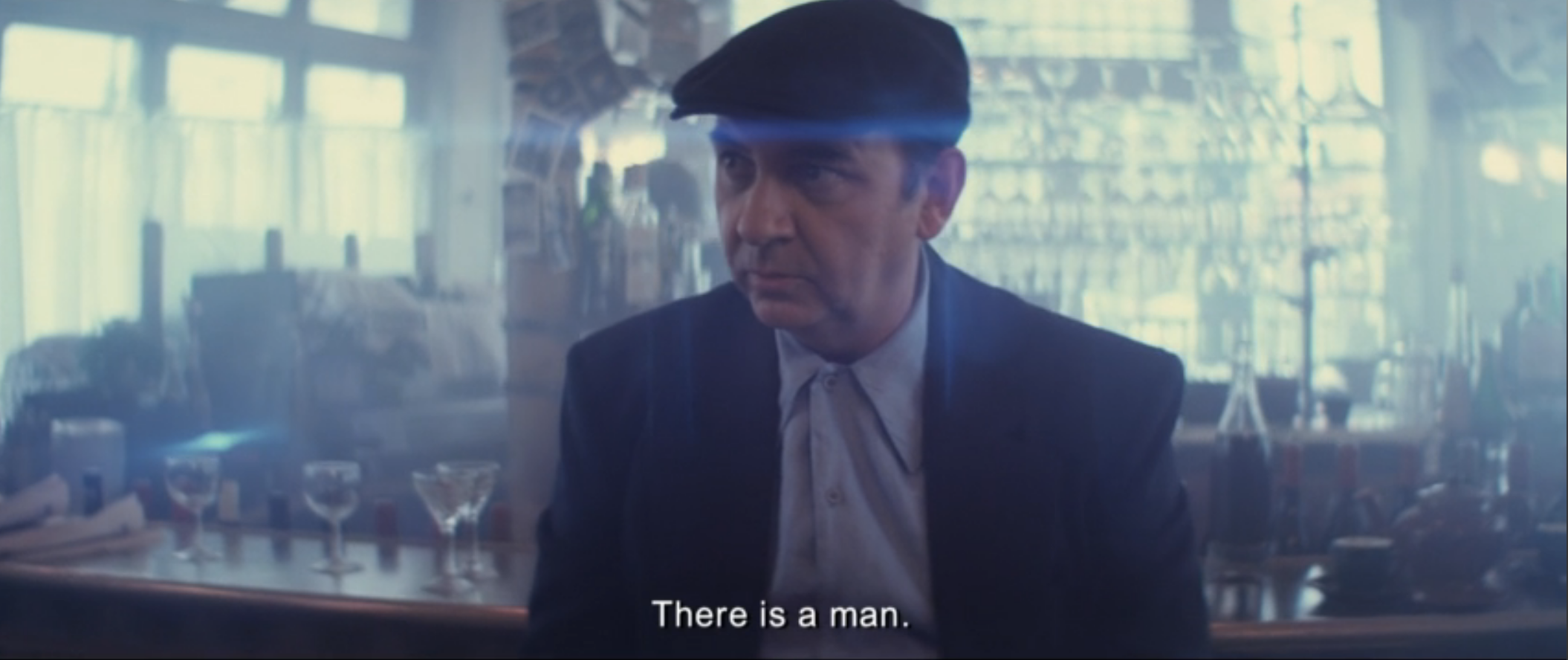 Neruda in Paris, against windows filled with light.
