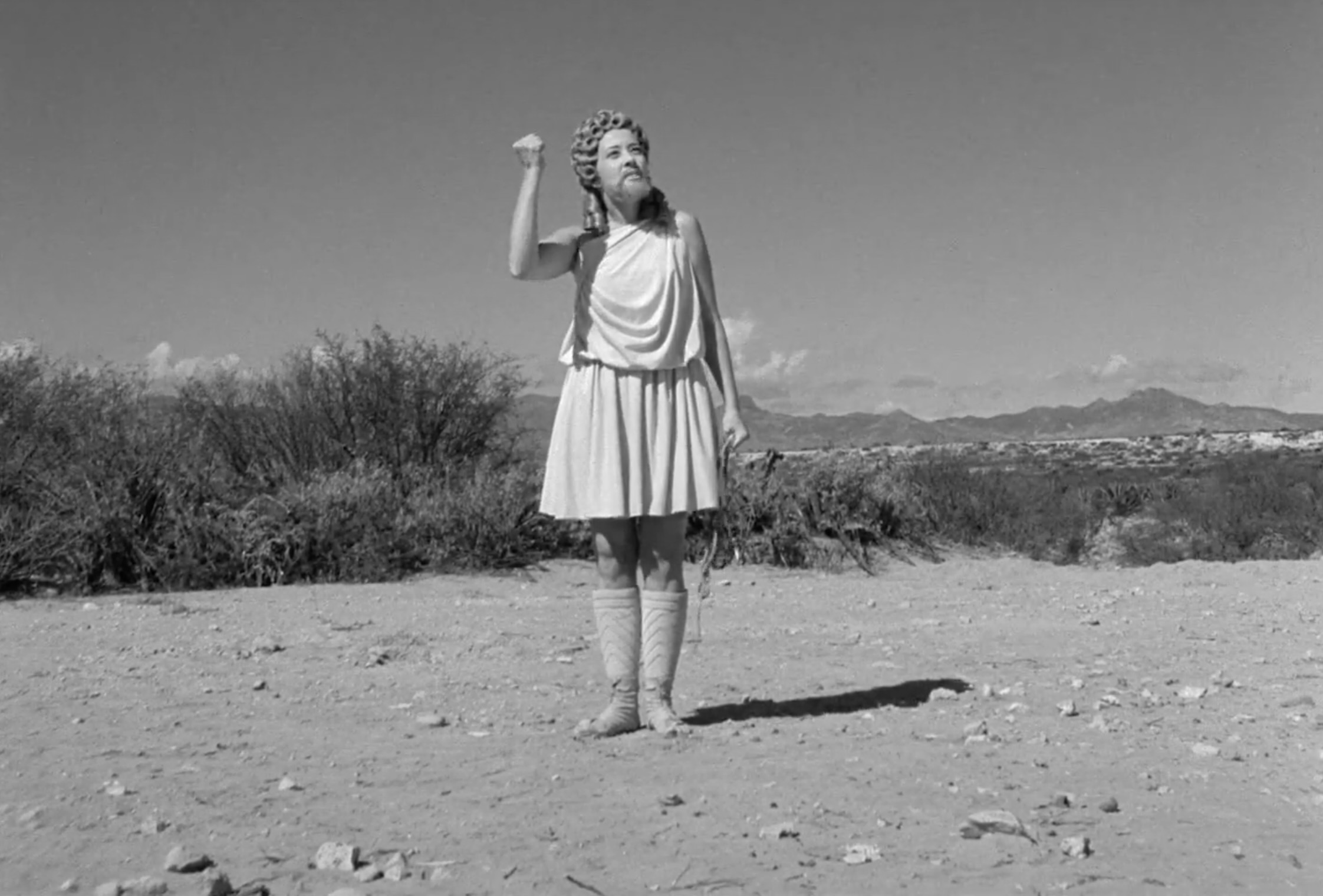 Satan throwing her fist in the air while promising that she will return.