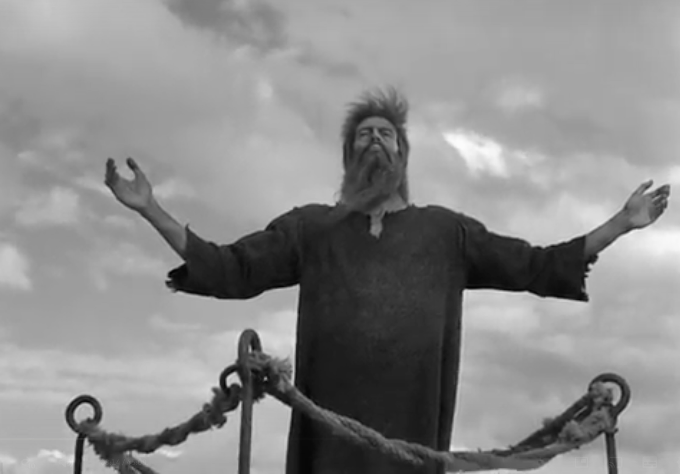 Simón praising with his arms raised wearing his squalid robe.