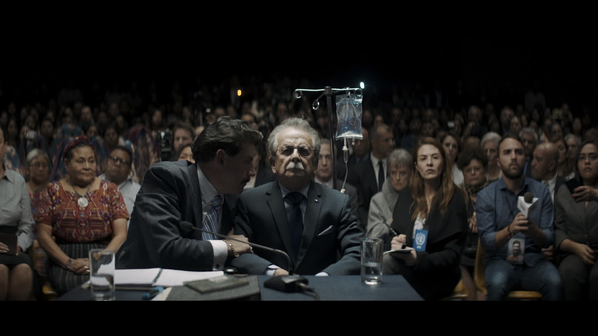 General Enrique Monteverda enfrentándose a sus crímenes, con los espectadores en el fondo.