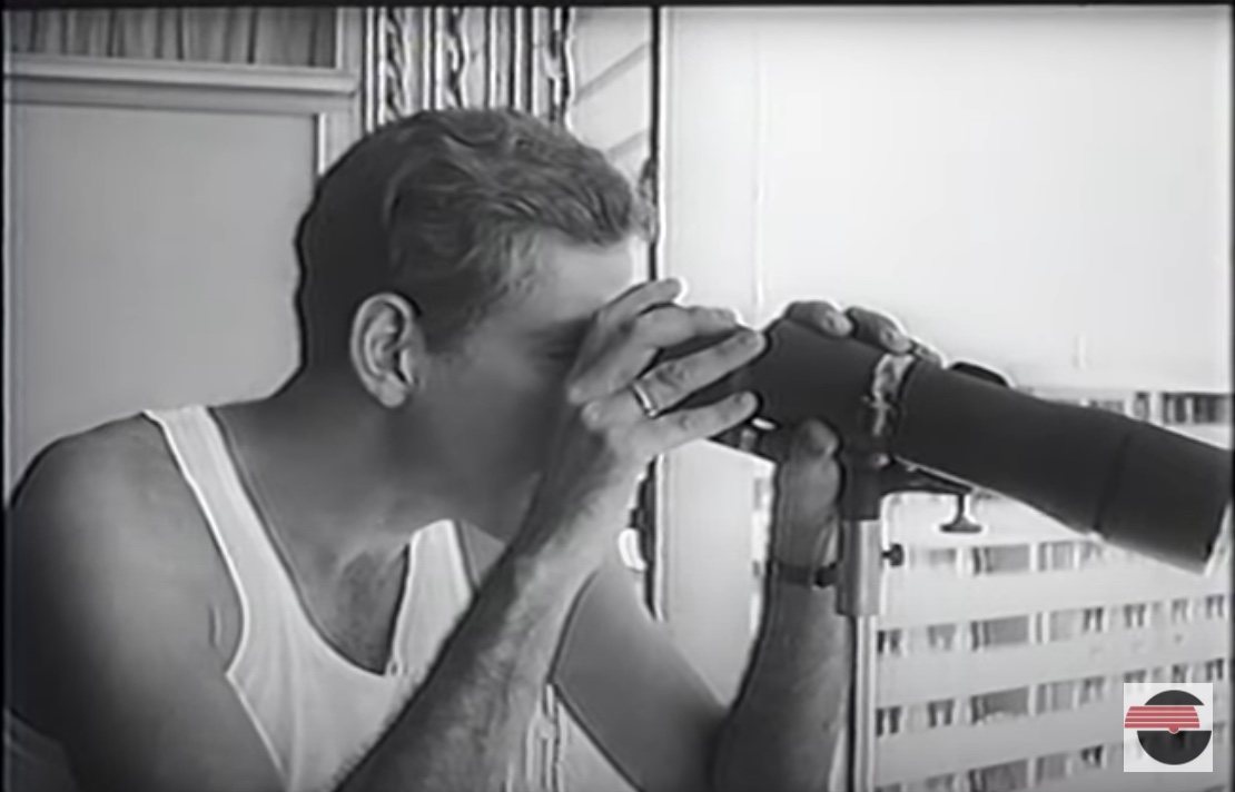 Sergio en su balcón, mirando a través de un telescopio a la ciudad