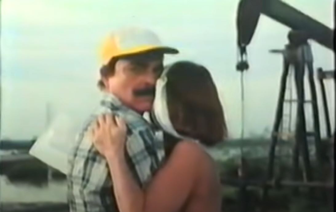 Julio and his wife in front of an oil rig