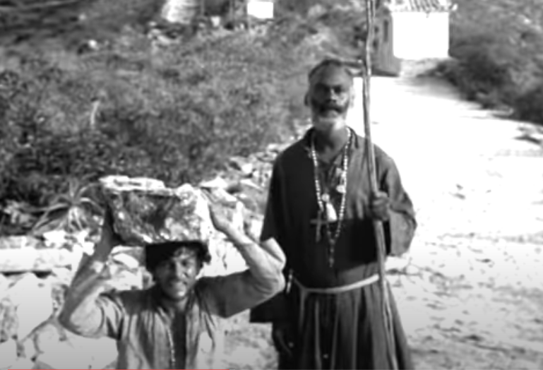 Manuel carries a heavy rock up the mountain to demonstrate his undying loyalty.
