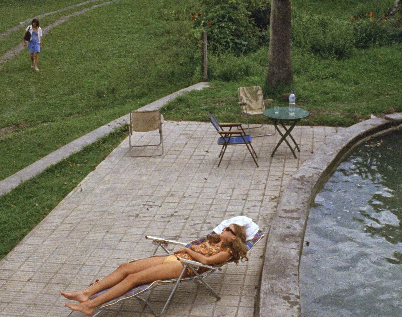 This is a picture of one of the daughters lounging outside on the rusty white outdoor chair.