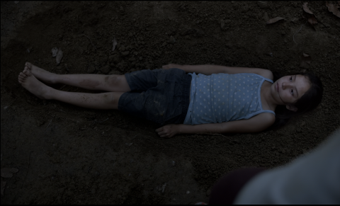 Ana lying in the pit to hide